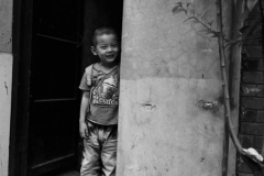 Une enfant de Pekin a la porte de sa maison