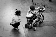 Two kids playing with a bicycle in Beijing